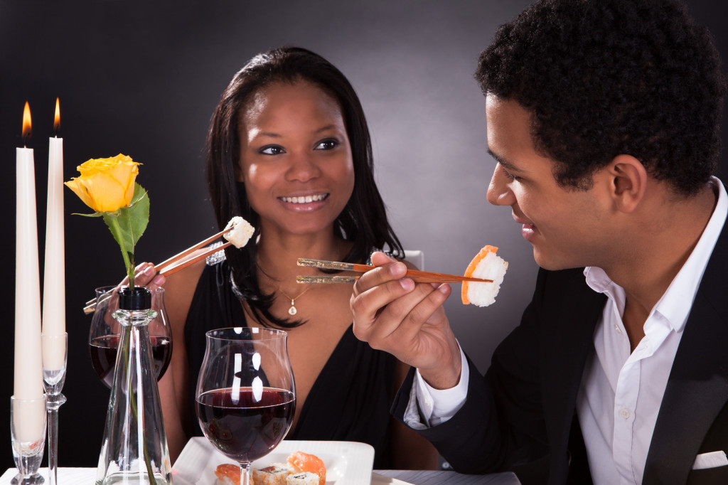 Portrait Of Romantic Couple Eating Sushi At Dinner