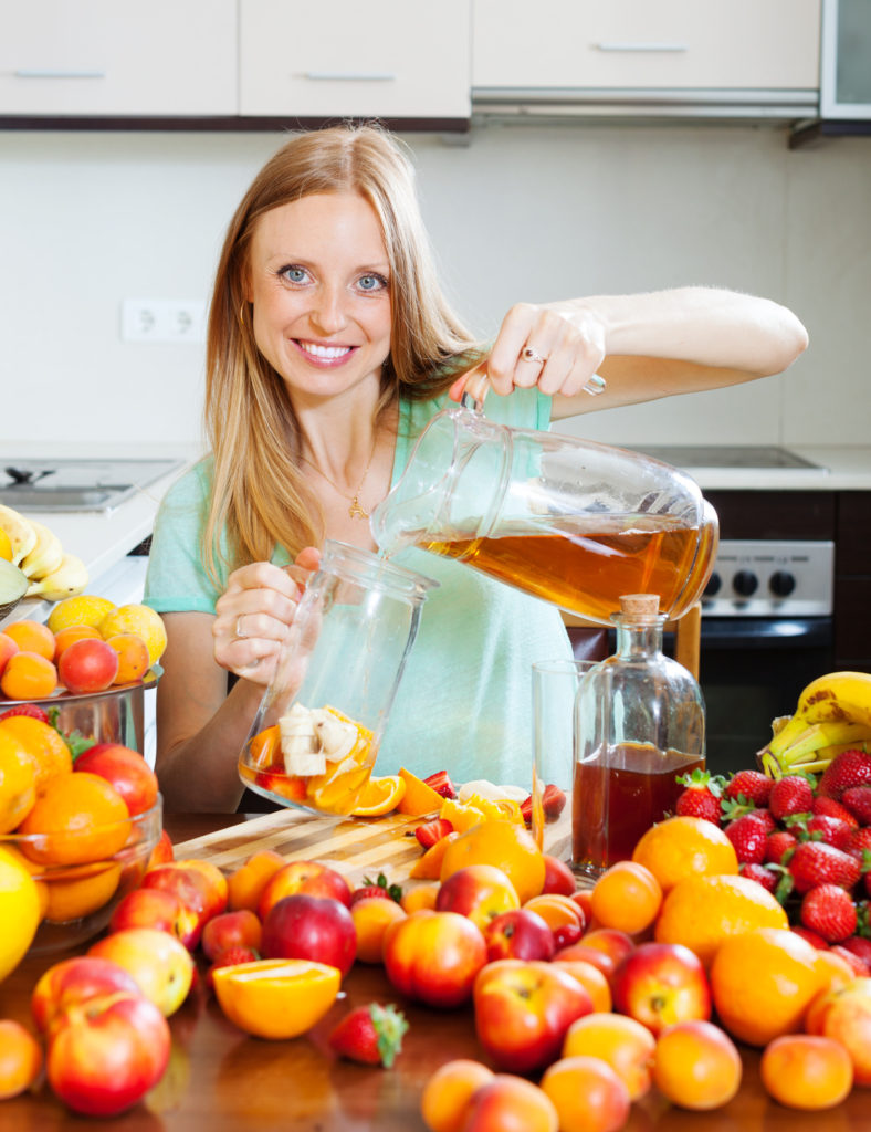 girl pouring fresh beverages with fruits